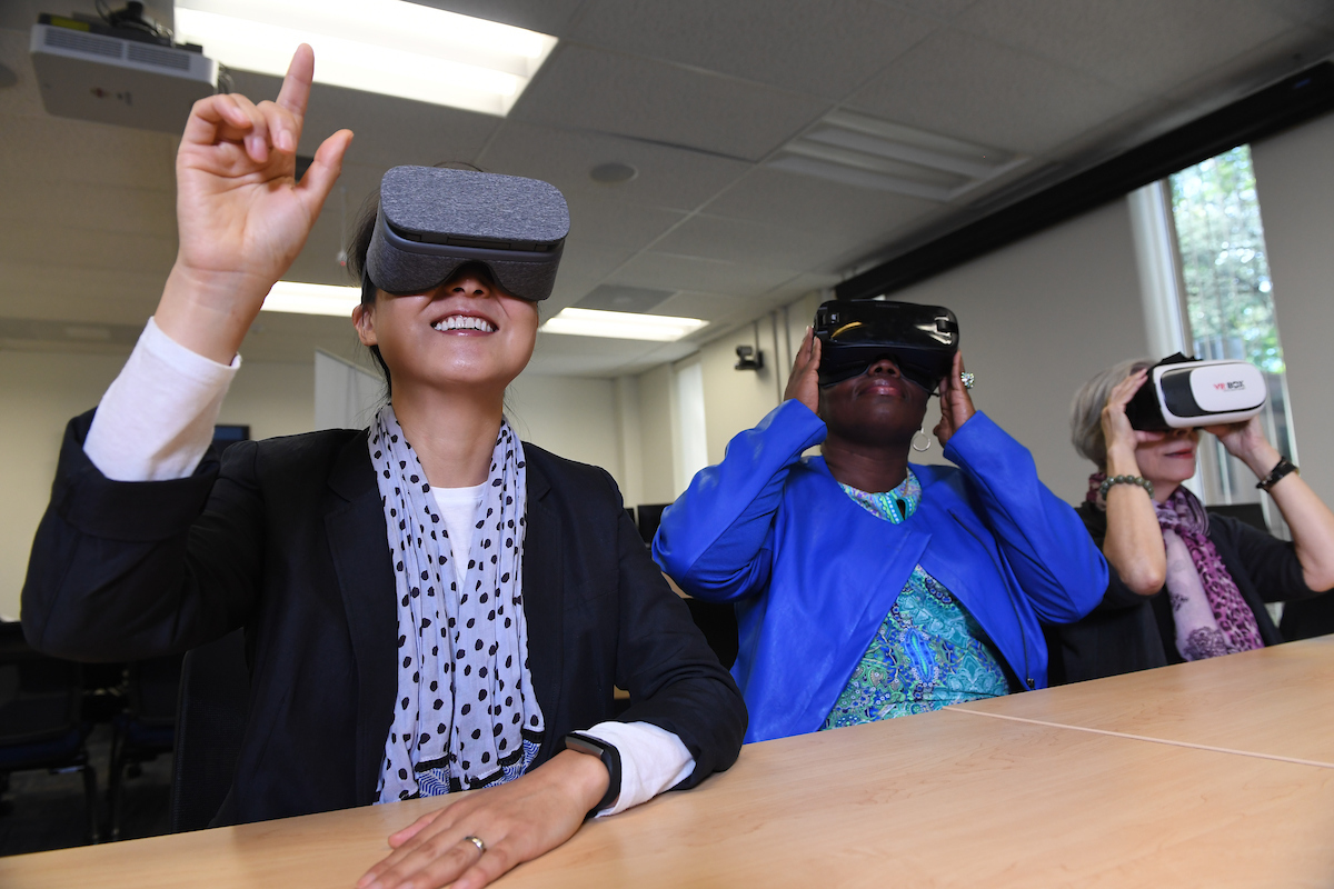 Three persons using VR goggles
